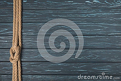 top view of background with brown nautical rope with knot on wooden planks Stock Photo