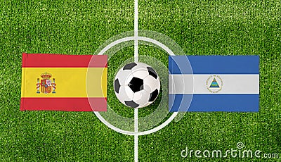 Top view ball with Spain vs. Nicaragua flags match on green soccer field Stock Photo