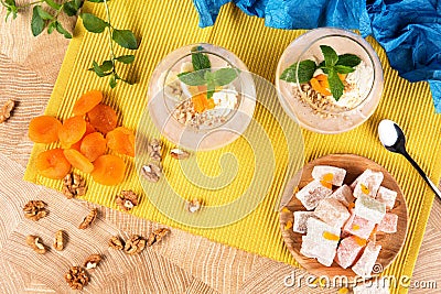 Top view of banana smoothies in a huge glasses with Turkish Delight, dried apricots and walnuts on multi-colored Stock Photo