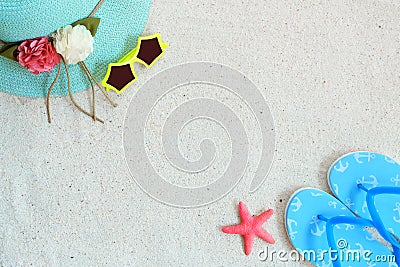 Top view of beach sand with straw hat, sunglasses, slippers and starfish. Stock Photo