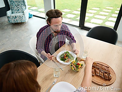 Top view of a beautiful heterosexual Caucasian loving couple having dinner together at home Stock Photo