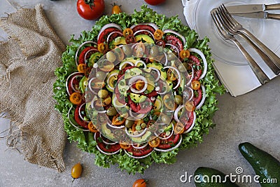 Top view of beautiful Mandala like fresh tomato, avocado, olives, lettuce and onion salad garnished with spring onion & nigella se Stock Photo