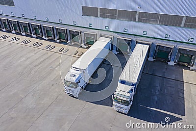 Top view at a Big distribution warehouse with gates for loads and trucks. Aerial View Editorial Stock Photo