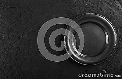 Top view of black empty plate on black stone background Stock Photo