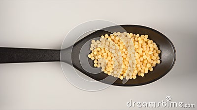 TOP VIEW: Black spoon with a couscous Stock Photo