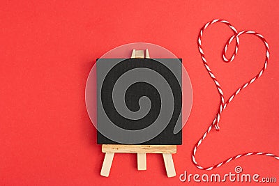 Top view of a blackboard with heart thread on a red background Stock Photo