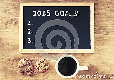 Top view of blackboard with the phrase 2015 goals over wooden board with coffe and cookies Stock Photo