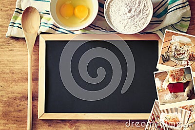 Top view of blackboard and wooden spoon over wooden table and collage of photos with various food and dishes. Stock Photo