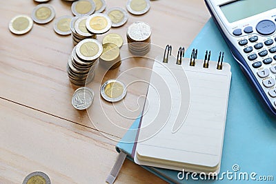 Top view of blank note book, Thai coins and calculator on wooden table Stock Photo