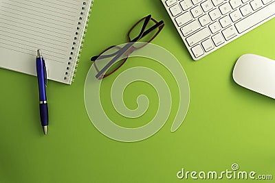 Top view of blank paper page on green background office desk and different objects. Minimal flat lay style Editorial Stock Photo