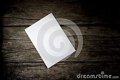 Top view of a blank sheet of white paper lying on a wooden rustic desk Stock Photo