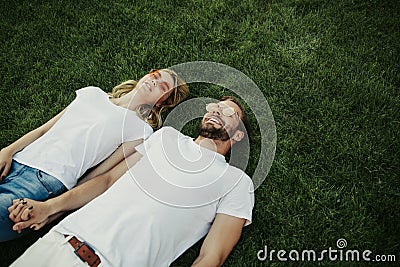 Joyous smiling couple looking up being on grass Stock Photo