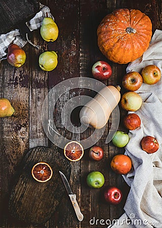 top view of blood oranges, pears, apples, pumpkins, wooden board and knife on rustic Stock Photo