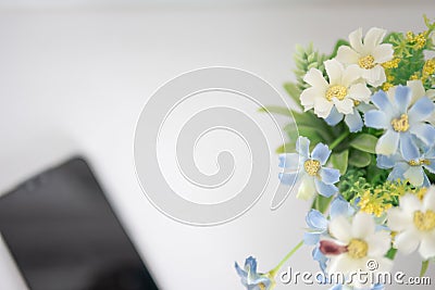 Top view blooming of fake flower and blurred mobile Stock Photo