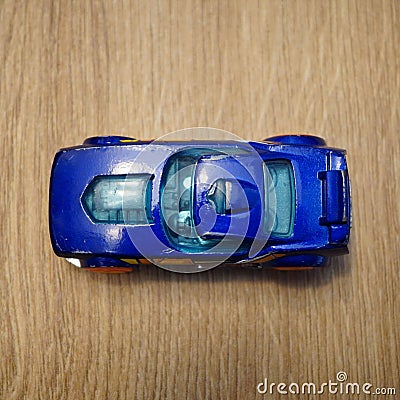 Top view of a blue Mattel Hot Wheels toy car on a wooden surface Editorial Stock Photo