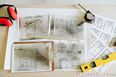 Top view of blueprints, ear defenders, level and tools on architect workspace at construction site Stock Photo