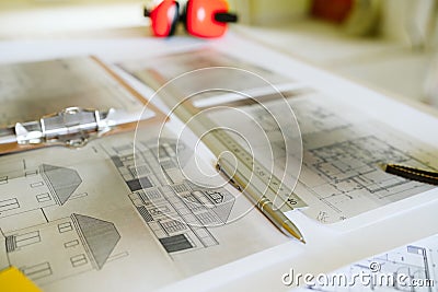 Top view of blueprints, ear defenders, level and tools on architect workspace at construction site Stock Photo