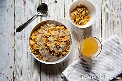 Top view of a bowl of cereal corn flakes and fruit juice Stock Photo