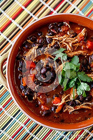 Top view a bowl of homemade chilli topped with cilantro leaves on a colorful table mat Stock Photo