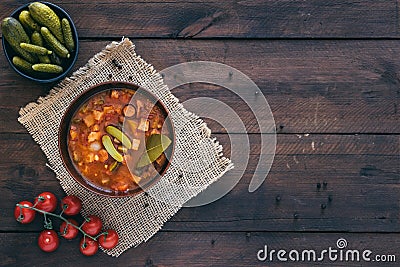 Top view of bowl with Solyanka, a spicy and sour soup of Russian origin, on dark wooden background with copy space Stock Photo
