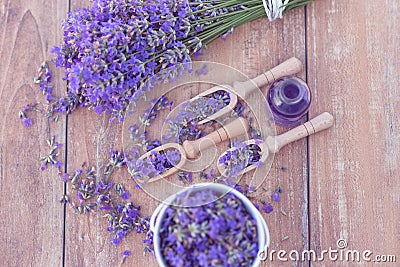 Top view of a bowl and wooden spoons with fresh lavender flowers, lavender essential oil and a bouquet of lavender Stock Photo
