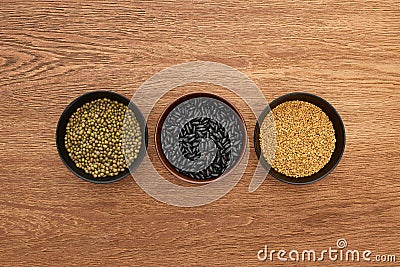 Top view of bowls with legumes and cereal on wooden surface. Stock Photo