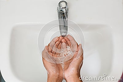 Top view of a boy cupped soapy hand against washbasin Stock Photo