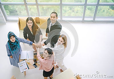 Top view of Business people in team stack hands together as unity and teamwork in office. young Asian businessman Stock Photo