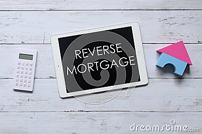 Top view of calculator,house model and tablet written with REVERSE MORTGAGE. Business and finance concept Stock Photo