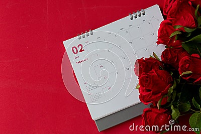 Top view calendar of February with blurred red rose flower on the red background desk the concept for Valentine's day Stock Photo