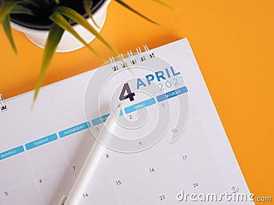 Top view, Calendar show page April 2021 with pen on yellow background. Stock Photo