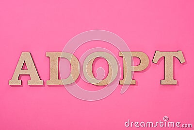 Top view of cardboard word adopt on pink background. Stock Photo