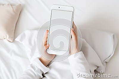 Top view child sitting and holding blank screen mock-up mobile phone AI generated Stock Photo