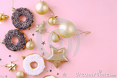 Top view of christmas composition decoration of snowflakes, stars, balls, donuts of golden and white color on a pink background. Stock Photo