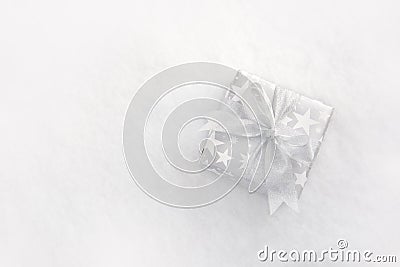 Top view of a christmas gift box in silver wrapping paper over a white fluffy background. Stock Photo