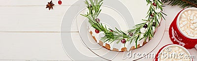 Top view of christmas pie with icing, rosemary and cranberries on white wooden table with cups of cocoa. Stock Photo