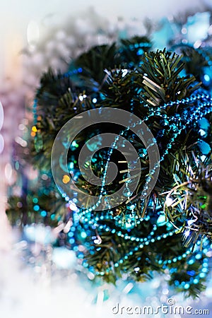 Top view of the Christmas tree, decorated with turquoise garlands, tinsel, glowing lights and artificial snow Stock Photo