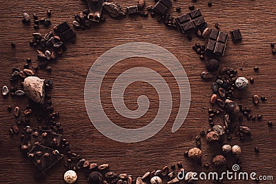 top view of circle made of various types of chocolate pieces, truffles, coffee grains and cocoa beans Stock Photo