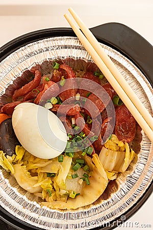 Clay pot rice of Chinese style sausage and salty duck egg and vegetable vertical composition Stock Photo
