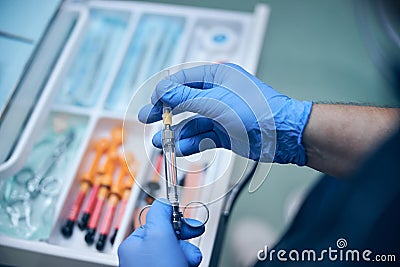 Male dentist taking painkiller injection for treatment Stock Photo