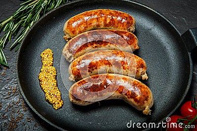 Top view closeip fried sausages on round pan with granular mustard Stock Photo