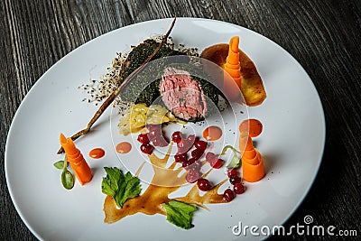 Top view closeup medium raw meat decorated with carrot and viburnum berries Stock Photo
