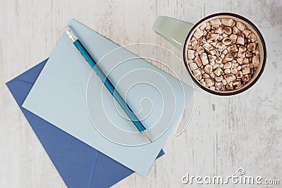Top view on cocoa with marshmallow and blue envelopes for letter Stock Photo