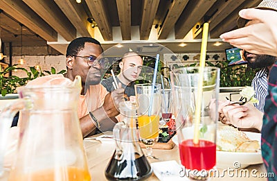 Top view. A company of multicultural company young people in a cafe eating sushi rolls, drinking drinks having fun Stock Photo