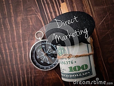 Top view compass, banknotes and coversation wooden board with text Direct Marketing Stock Photo