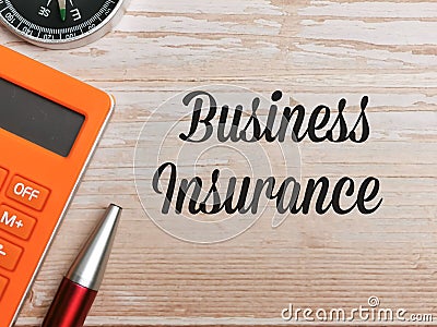 Top view compass,calculator and pen with text BUSINESS INSURANCE written on wooden background. Stock Photo