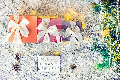 Top view composition of lighted box with Merry Christmas and New year wishes and presents in colorful festive wrapping tied with Stock Photo