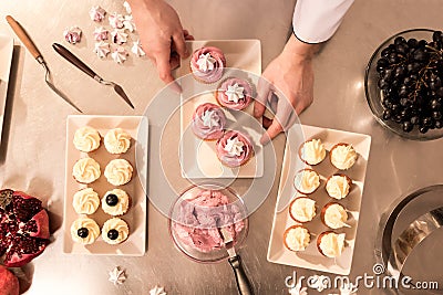top view of confectioner arranging cupcakes Stock Photo