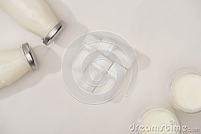 Top view of containers with starter cultures with bottles and glasses of yogurt Stock Photo