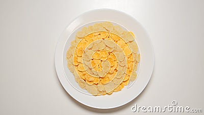TOP VIEW: Corn flakes on a white dish on a white table Stock Photo